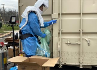A Battelle employee loads used N95 masks into the sealed decontamination chamber