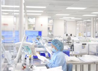 Evolve employee Liberty Domingo demonstrates cleanroom manufacturing of cervical implants used in spinal surgery.