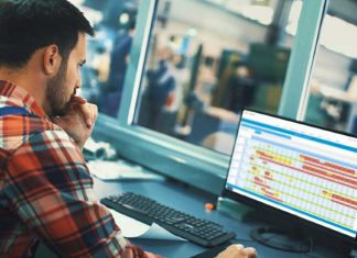 A manufacturing worker analyzes production and inventory data through Plex’s solution.