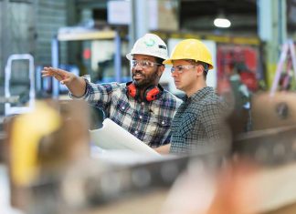 manufacturing workers in facility wearing hard hats