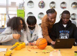 Students from Burke High School in Boston explore Scratch coding with an MIT Research Assistant at a Waters Student Academy event.