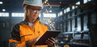 Woman in manufacturing warehouse using an iPad.