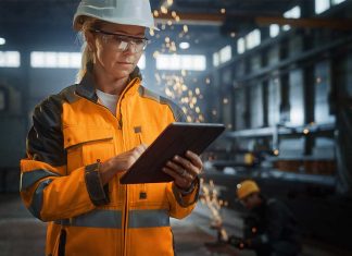Woman in manufacturing warehouse using an iPad.